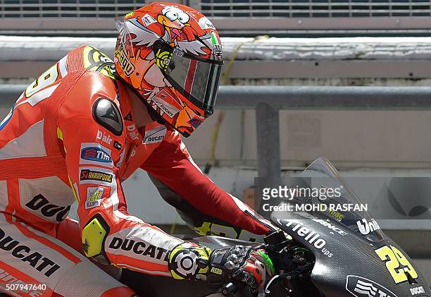 Ducati Team rider Andrea Iannone of Italy wears a helmet with a tribute to a seagull he hit in Australia last season as he rides in pit lane during...
