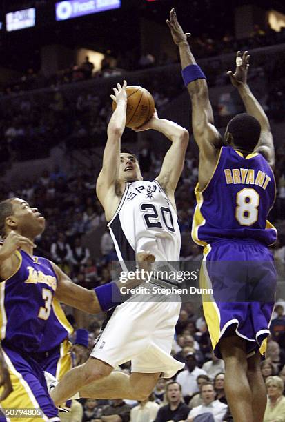 Emanuel Ginobili of the San Antonio Spurs goes up for a shot between Kobe Bryant and Devean George of the Los Angeles Lakers during Game one of the...