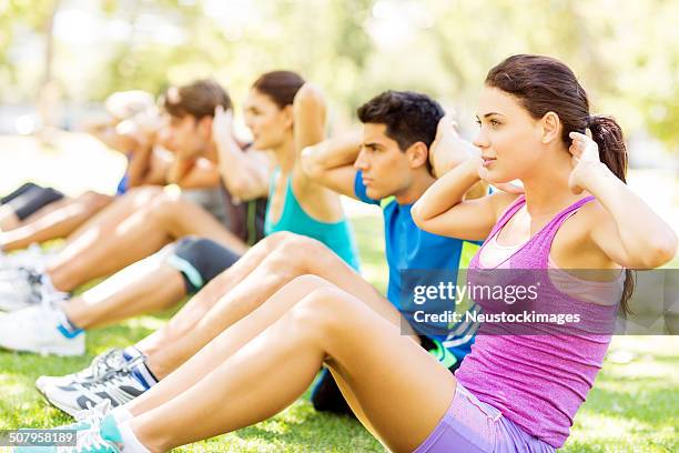 young people doing sit-ups in park - military camp stock pictures, royalty-free photos & images