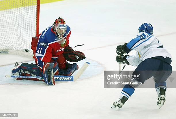 Jukka Hentunen of Finland scores against goalie Igor Podomatsky of Russia in the teams' Group F qualifier match at the International Ice Hockey...