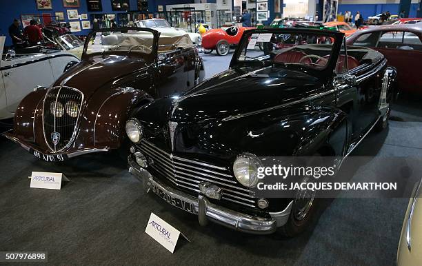 Photo shows a 1939 Peugeot 202 cabriolet and a 1955 Peugeot 203 C cabriolet on display at the Artcurial stand of the Retromobile show in Paris on...