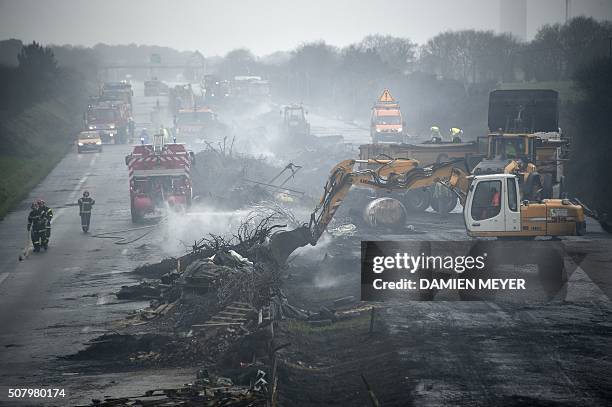 Firemen and employees clean the RN165 highway near Arzal, western France, on February 2, 2016 after a week of demonstrations and road blockades by...