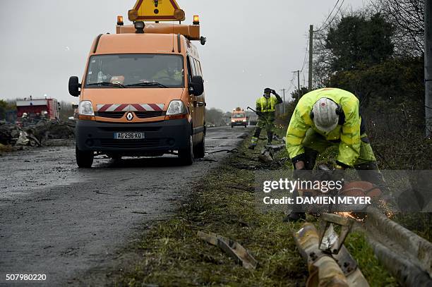 Employees clean the RN165 highway near Arzal, western France, on February 2, 2016 after a week of demonstrations and road blockades by farmers....