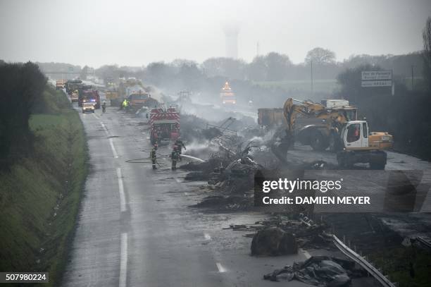 Firemen and employees clean the RN165 highway near Arzal, western France, on February 2, 2016 after a week of demonstrations and road blockades by...