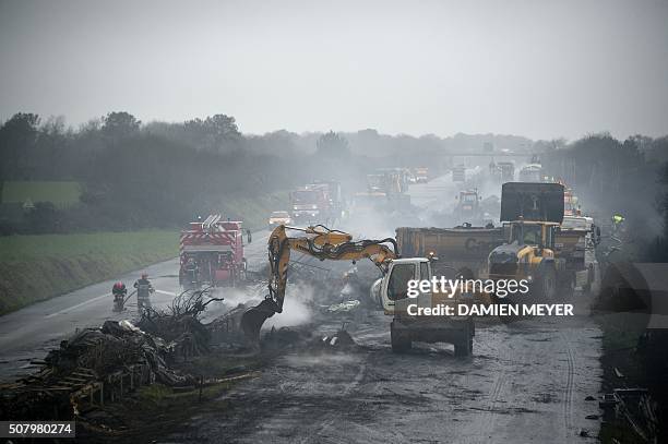 Firemen and employees clean the RN165 highway near Arzal, western France, on February 2, 2016 after a week of demonstrations and road blockades by...