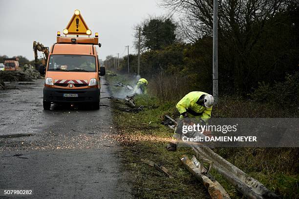 Employees clean the RN165 highway near Arzal, western France, on February 2, 2016 after a week of demonstrations and road blockades by farmers....