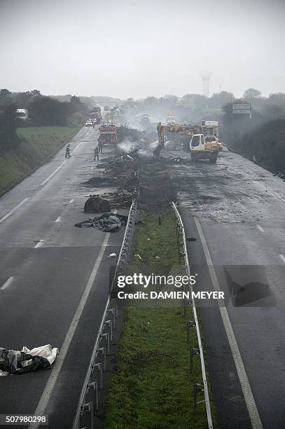 Firemen and employees clean the RN165 highway near Arzal, western France, on February 2, 2016 after a week of demonstrations and road blockades by...