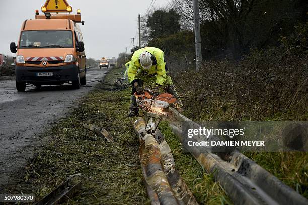 Employees clean the RN165 highway near Arzal, western France, on February 2, 2016 after a week of demonstrations and road blockades by farmers....