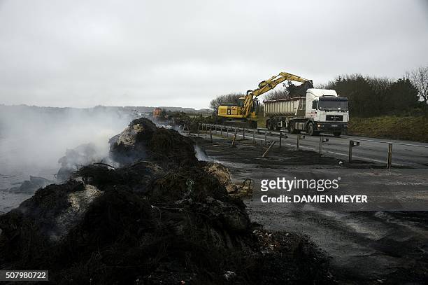 Photo taken on February 2, 2016 shows the cleaning of the RN165 highway near Arzal, western France, after a week of demonstrations and road blockades...