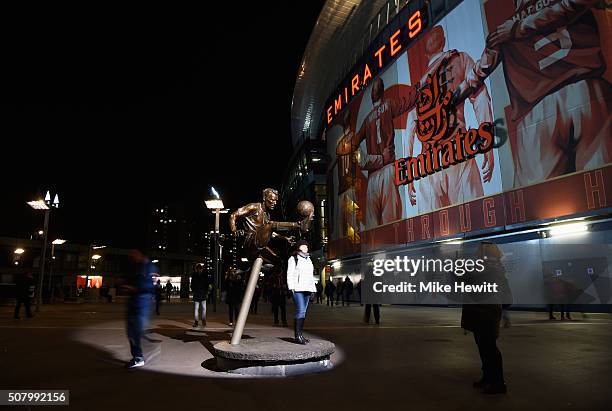 Fan poses for photographs next to the Dennis Bergkamp statue prior to the Barclays Premier League match between Arsenal and Southampton at the...