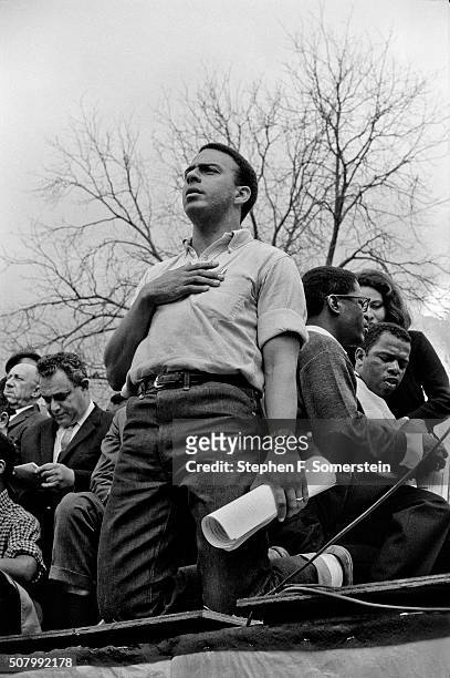 Civil rights leader Andrew Young with his hand over his heart and on his knees after singing of the National Anthem. Bernard King and John Lewisare...