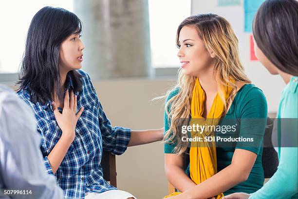 therapist counsels teenage girl in support group - cheftrainer stockfoto's en -beelden