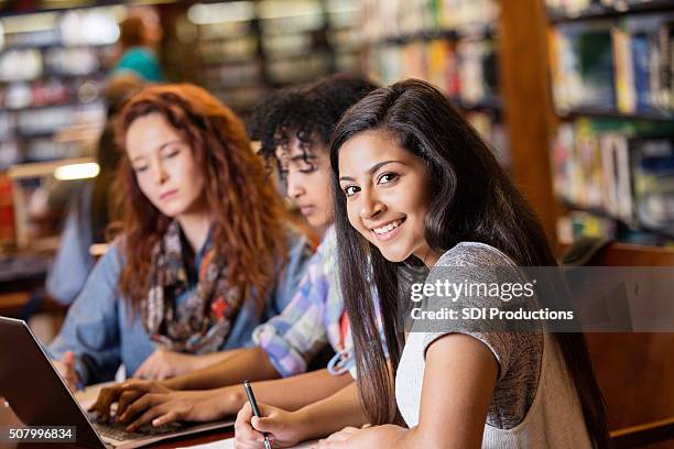 indian teen studying in library with college age friends - female high school student stock pictures, royalty-free photos & images