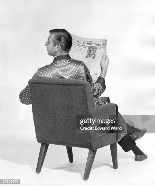 Gentleman in dressing gown and slippers reading the Sunday Times.