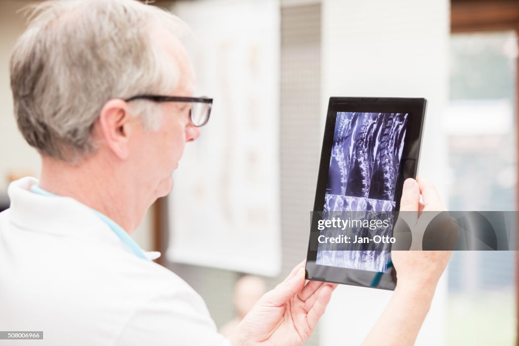 Doctor checking MRI images on tablet PC