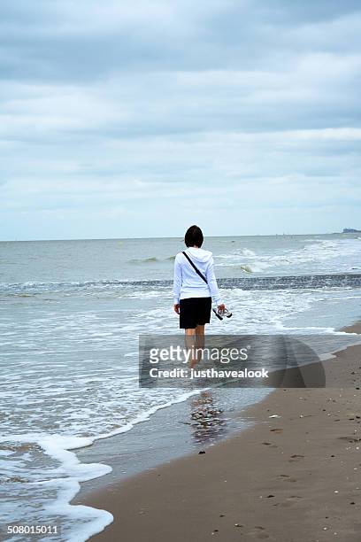 donna a piedi nel surf - beach of ostende foto e immagini stock