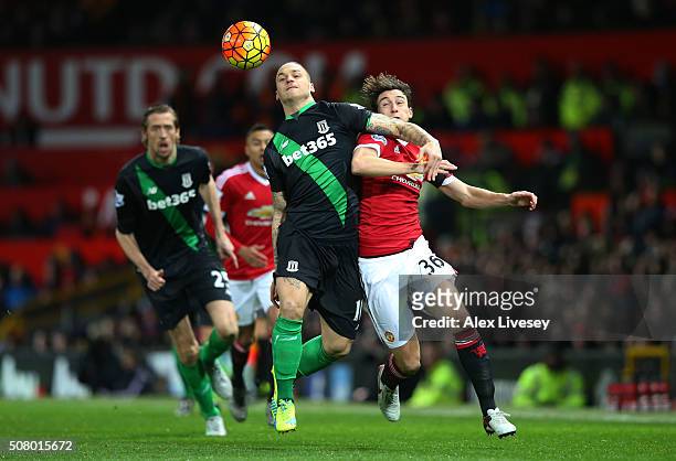 Marko Arnautovic of Stoke City and Matteo Darmian of Manchester United compete for the ball during the Barclays Premier League match between...