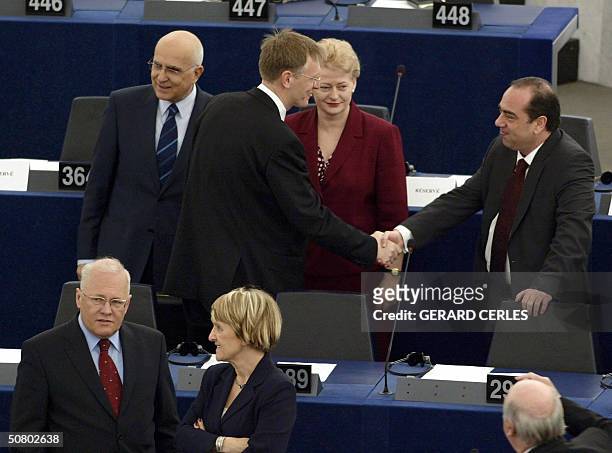 New Slovenian commissioner Janez Potocnik shakes hands with his Cyprus counterpart Markos Kyprianou while Lithuania's commissioner Dalia Grybauskaite...