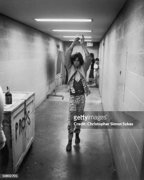 Mick Jagger limbers up before a show during the Rolling Stones Tour of the Americas, 1975.