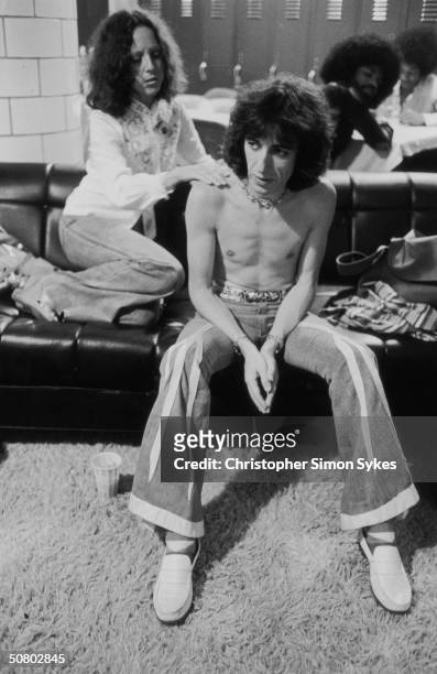 Bassist Bill Wyman receives a shoulder massage backstage during the Rolling Stones' 1975 Tour of the Americas.