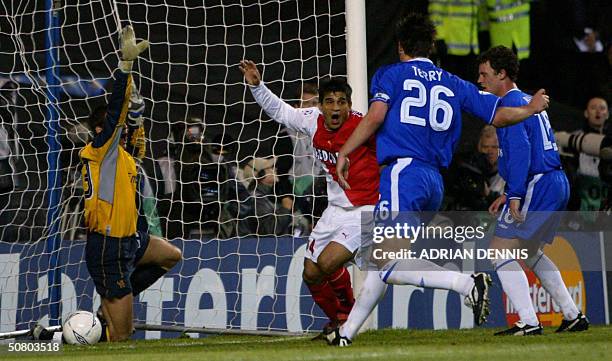 Monaco's Hugo Ibarra scores against Chelsea's goal keeper Carlo Cudicini as his teammates John Terry and Wayne Bridge watch during their semi-final...