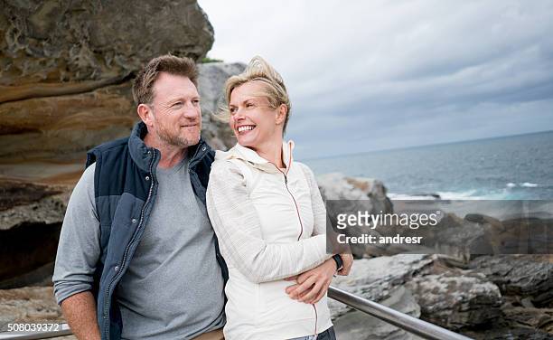 loving couple walking by the beach - australian winter stockfoto's en -beelden