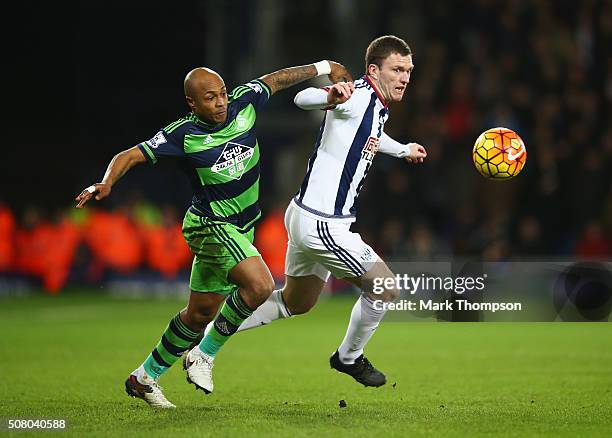 Andre Ayew of Swansea City and Craig Gardner of West Bromwich Albion compete for the ball during the Barclays Premier League match between West...