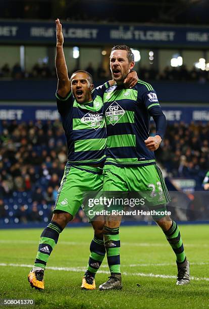 Gylfi Sigurdsson of Swansea City celebrates scoring his team's first goal with his team mate Wayne Routledge during the Barclays Premier League match...