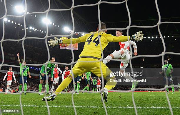 Fraser Forster of Southampton makes a save a shot by Mesut Ozil of Arsenal during the Barclays Premier League match between Arsenal and Southampton...