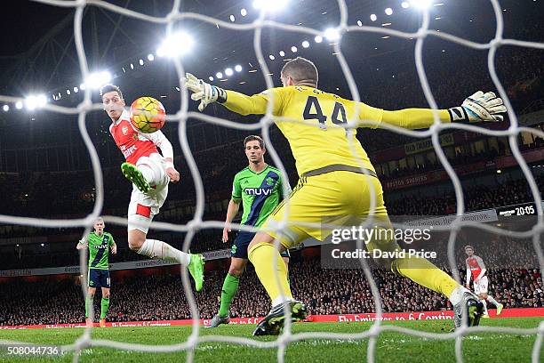 Mesut Ozil of Arsenal has his shot saved Fraser Forster of Southampton during the Barclays Premier League match between Arsenal and Southampton at...