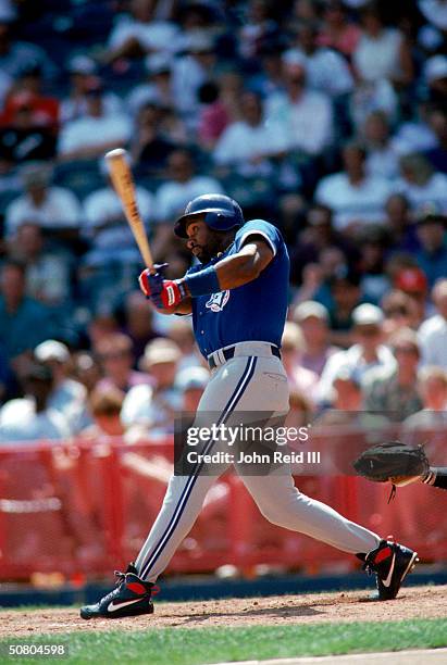 Joe Carter of the Toronto Blue Jays follows through on a swing during a game against the Brewers on June 30, 1994 at Milwaukee County Stadium in...