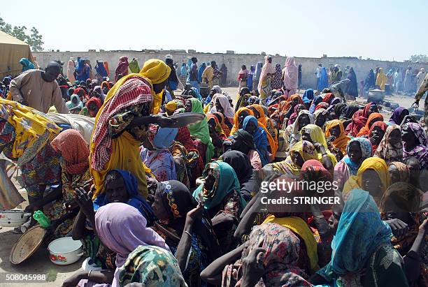Internally Displaced Persons mostly women and children sit waiting to be served with food at Dikwa Camp, in Borno State in north-eastern Nigeria, on...
