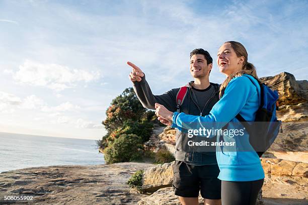 couple hiking and pointing away - eco tourism australia stock pictures, royalty-free photos & images