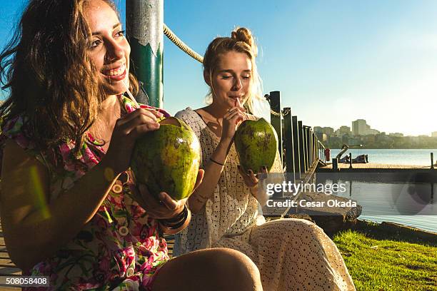 ragazze a bere acqua di cocco - acqua di cocco foto e immagini stock