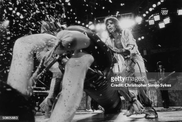 Mick Jagger and percussionist Ollie Brown manoeuvre a stage prop known as 'The Dragon' into place during a concert at the LA Forum on the Rolling...