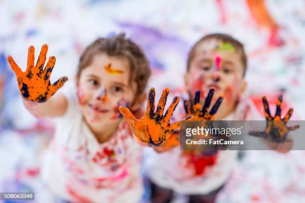 divertimento bambini pittura con le dita fratello e sorella - 4 girls finger painting foto e immagini stock