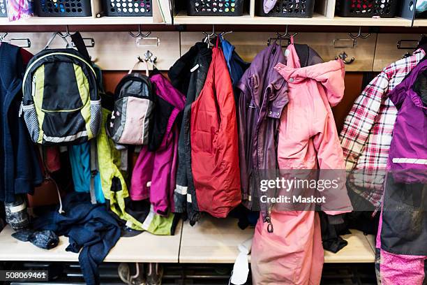 winter coats and backpacks in wardrobe at kindergarten - daycare stock pictures, royalty-free photos & images