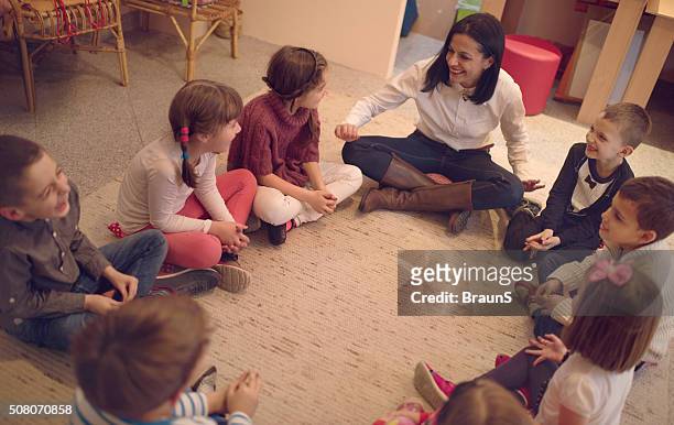 above view of preschool teacher talking to group of kids. - children circle floor stock pictures, royalty-free photos & images
