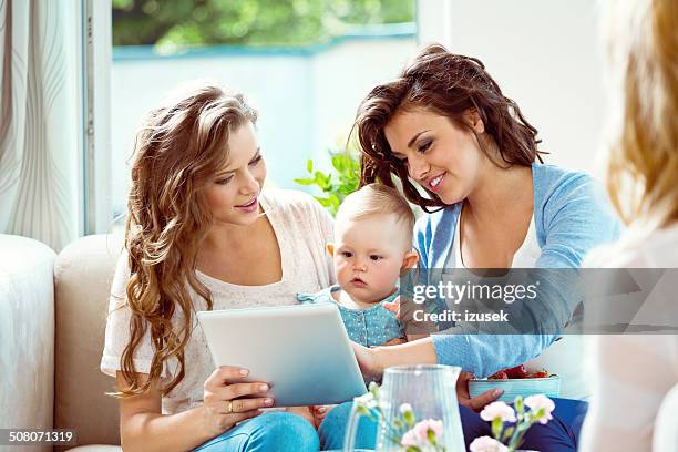 junge mutter und baby mädchen mit tablet pc - international mother language day stock-fotos und bilder