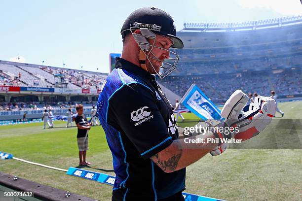 Brendon McCullum of New Zealand gloves up before taking the field in the One Day International match between New Zealand and Australia at Eden Park...
