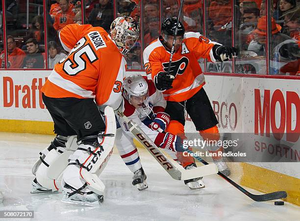 Steve Mason and Mark Streit of the Philadelphia Flyers combine to check Brendan Gallagher of the Montreal Canadiens as they pursue the loose puck...