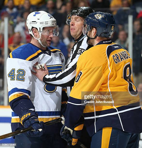Linesman Pierre Racicot separates David Backes of the St. Louis Blues and Petter Granberg of the Nashville Predators during an NHL game at...