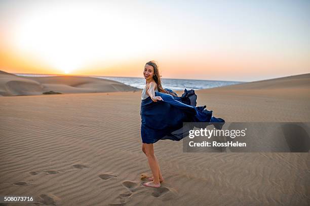 woman on the sand dunes - windy skirt 個照片及圖片檔