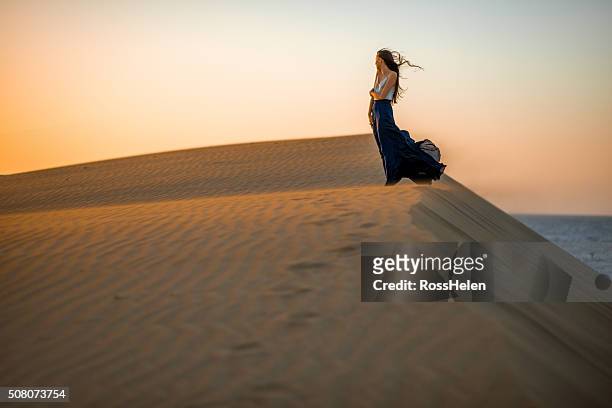 woman on the sand dunes - windy skirt 個照片及圖片檔
