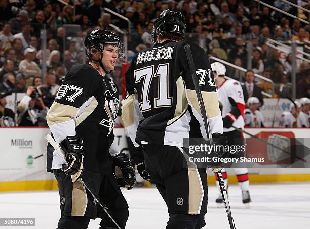 Sidney Crosby of the Pittsburgh Penguins talks with Evgeni Malkin during the second period against the Ottawa Senators at Consol Energy Center on...