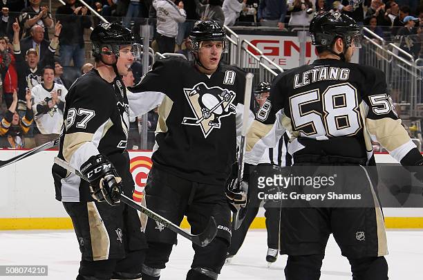 Sidney Crosby of the Pittsburgh Penguins celebrates his second goal of the game with Evgeni Malkin and Kris Letang during the second period against...