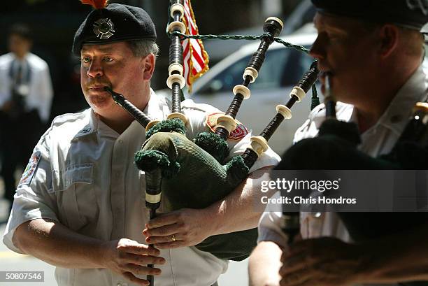 Firefighter John O'Hagan with the Emerald Society Bagpipe Band drones on bagpipes during a ceremony for Engine Company 43 in the Bronx honoring the...