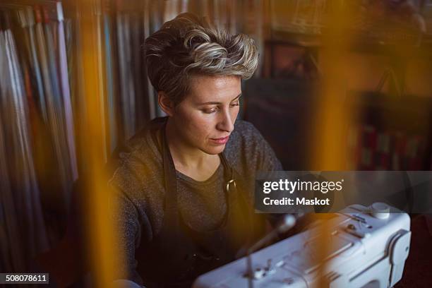 female fashion designer using sewing machine in design studio - upholstery worker stock pictures, royalty-free photos & images