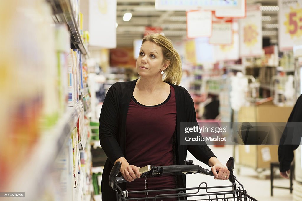 Mid adult woman buying groceries in supermarket