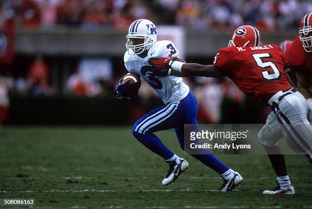 Craig Yeast of the Kentucky Wildcats runs with the ball as Ronald Bailey of the Georgia Bulldogs goes for the tackle on October 27, 1997 at Sanford...